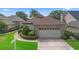 Inviting home with manicured shrubs, brick accents, a two-car garage, and picturesque lake views in a desirable location at 842 Bentley Green Cir, Winter Springs, FL 32708
