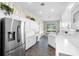Beautifully updated kitchen with stainless steel appliances, white cabinets, stone flooring, and charming wallpaper at 842 Bentley Green Cir, Winter Springs, FL 32708