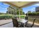 Covered patio with golf course view features a table and chairs, perfect for enjoying the outdoors in any weather at 842 Bentley Green Cir, Winter Springs, FL 32708