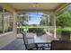 A screened-in patio has a table and four chairs with a view of the golf course at 842 Bentley Green Cir, Winter Springs, FL 32708