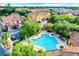 Aerial view of the community pool surrounded by townhomes, trees and a parking area at 8818 Villa View Cir # 304, Orlando, FL 32821
