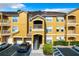Three-story yellow condo building featuring private balconies and garage parking at 8818 Villa View Cir # 304, Orlando, FL 32821