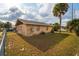 A view of the backyard with a well kept yard and a mature palm tree at 99 Rainbow Dr. # 4, Haines City, FL 33844