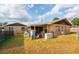 Backyard featuring a covered patio, generator, and well-maintained lawn at 99 Rainbow Dr. # 4, Haines City, FL 33844