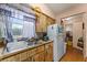 Kitchen featuring wood cabinets, a stainless steel sink, and a white refrigerator at 99 Rainbow Dr. # 4, Haines City, FL 33844