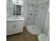 Bathroom featuring a new shower, vanity with white cabinets, quartz countertops and wood flooring at 1007 Colyer St, Orlando, FL 32805