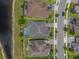 Aerial view of upscale homes with manicured lawns in a pristine community near a pond and paved street at 10742 Belle Maisons Dr, Orlando, FL 32832