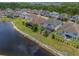 Aerial view of the house with the screened-in lanai and pool in a landscaped backyard close to a pond at 10742 Belle Maisons Dr, Orlando, FL 32832