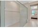 Modern walk-in shower with a glass enclosure and a neutral color palette, steps from main bedroom at 10742 Belle Maisons Dr, Orlando, FL 32832
