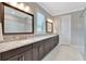Elegant bathroom featuring dual sinks, granite countertops, and dark wood cabinetry at 10742 Belle Maisons Dr, Orlando, FL 32832