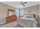 Comfortable bedroom with natural light, ceiling fan, and a dresser with a mirror at 10742 Belle Maisons Dr, Orlando, FL 32832