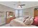 Cozy bedroom with neutral walls, carpet, and ample natural light from the shuttered windows at 10742 Belle Maisons Dr, Orlando, FL 32832