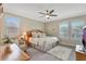Inviting bedroom with neutral tones, a ceiling fan, and natural light from the shuttered windows at 10742 Belle Maisons Dr, Orlando, FL 32832