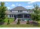Exterior view of the back of the house showcasing the screened-in lanai and pool in a landscaped backyard at 10742 Belle Maisons Dr, Orlando, FL 32832