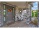 Charming front porch featuring stone columns, seating area, and a welcoming entrance at 10742 Belle Maisons Dr, Orlando, FL 32832
