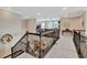 Spacious hallway with iron railing overlooking the foyer and open floor plan at 10742 Belle Maisons Dr, Orlando, FL 32832