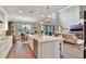 Open kitchen with granite counters, an island, barstool seating, dining area and living room at 10742 Belle Maisons Dr, Orlando, FL 32832