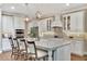 Large kitchen island with seating, stylish pendant lights, and stainless steel appliances at 10742 Belle Maisons Dr, Orlando, FL 32832