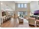 Bright, open living space with wood-look flooring, high ceilings and neutral decor, seamlessly flowing into the kitchen at 10742 Belle Maisons Dr, Orlando, FL 32832