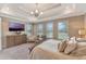 Main bedroom features tray ceilings, carpet, natural light, and a TV for ultimate comfort and relaxation at 10742 Belle Maisons Dr, Orlando, FL 32832