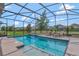 A screened-in pool and spa are surrounded by an outdoor patio area with comfortable chaise lounge seating at 10742 Belle Maisons Dr, Orlando, FL 32832