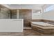 Bathroom with a soaking tub and separate shower featuring elegant tile work and bright, natural light at 10819 Savona Way, Orlando, FL 32827