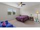 Comfortable bedroom featuring a floral bedspread, ceiling fan, and natural light from two windows at 10819 Savona Way, Orlando, FL 32827