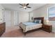 Bedroom with a ceiling fan, two large windows, and a dark wood dresser at 10819 Savona Way, Orlando, FL 32827