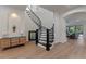 Elegant entryway with a curved staircase, wood flooring, and archways to the living area at 10819 Savona Way, Orlando, FL 32827