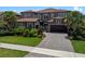Beautiful two-story home with lush landscaping, brick paved driveway, and a red tile roof at 10819 Savona Way, Orlando, FL 32827