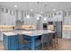 Gourmet kitchen with white cabinets, stainless appliances, a large island, quartz countertops, and modern pendant lighting at 10819 Savona Way, Orlando, FL 32827