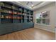 Stylish library room showcasing custom blue built-in shelving and wood floors at 10819 Savona Way, Orlando, FL 32827
