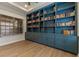 Well-lit library room with beautiful built-in blue shelving, cabinets and neutral walls at 10819 Savona Way, Orlando, FL 32827