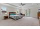 Spacious main bedroom with a king bed, ensuite bathroom, and carpet flooring with a ceiling fan at 10819 Savona Way, Orlando, FL 32827