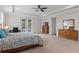 Spacious main bedroom with a king bed, ensuite bathroom, and carpet flooring with a ceiling fan at 10819 Savona Way, Orlando, FL 32827