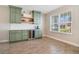 This bar area includes green cabinets, a wine fridge, a beverage cooler and light wood-look ceramic flooring at 1115 Oak Bluff Dr, Davenport, FL 33837