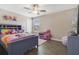 Bright bedroom with playful decor, ceiling fan, and a large window at 1115 Oak Bluff Dr, Davenport, FL 33837