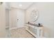 The entryway features a wood-look ceramic tile floor, a white wooden table, and a decorative mirror on the wall at 1115 Oak Bluff Dr, Davenport, FL 33837