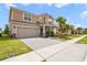 Charming two-story home features a two car garage, tile roof, front yard landscaping and brick paved drive at 1115 Oak Bluff Dr, Davenport, FL 33837