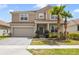 Charming two-story home features a two car garage, tile roof, front yard landscaping and brick paved drive at 1115 Oak Bluff Dr, Davenport, FL 33837