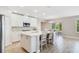 The kitchen has white cabinets, an island with seating, stainless steel appliances and ceramic wood look tile flooring at 1115 Oak Bluff Dr, Davenport, FL 33837