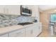 Close up of the kitchen with custom tile backsplash, stainless steel appliances, and white cabinetry at 1115 Oak Bluff Dr, Davenport, FL 33837