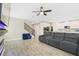 Open-concept living room with view into kitchen, modern fireplace, and staircase at 1115 Oak Bluff Dr, Davenport, FL 33837