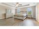 Spacious main bedroom with wood-look floors, tray ceiling, and large windows at 1115 Oak Bluff Dr, Davenport, FL 33837