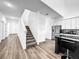 Bright entryway features hardwood floors, a staircase, and a view into the modern kitchen with stainless steel appliances at 1210 Lone Palm Way, St Cloud, FL 34771