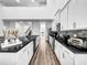 Modern, open-concept kitchen featuring white cabinets, granite countertops, and stainless steel appliances at 1210 Lone Palm Way, St Cloud, FL 34771