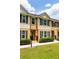 Inviting townhome with tan siding, dark shutters, manicured lawn, and well-maintained landscaping at 1255 Marley Ln, Winter Springs, FL 32708