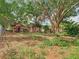 Backyard with a shed and outbuilding surrounded by overgrown vegetation and a large tree at 1263 Dunbar St, Altamonte Springs, FL 32701