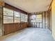 Room requiring renovation with damaged walls, many windows, and a concrete floor at 1263 Dunbar St, Altamonte Springs, FL 32701