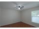 This bedroom offers ceramic wood-look floors, a ceiling fan, and natural light from the window at 1312 Catalina Blvd, Deltona, FL 32725